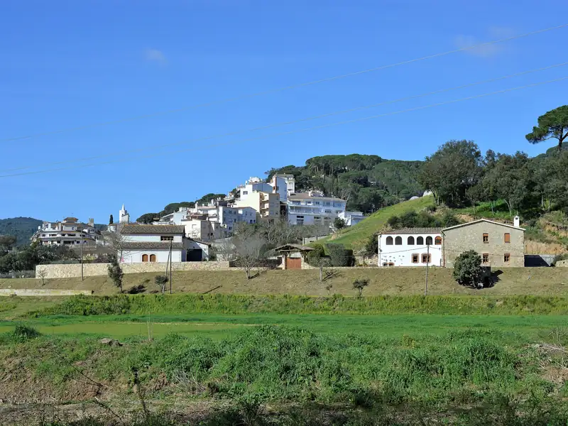Casas de Sant Cebrià de Vallalta en la ladera, sobre los campos