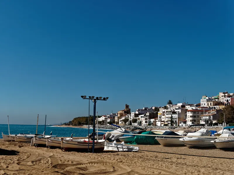 Barcas en la playa de Sant Pol de Mar con el pueblo blanco detrás
